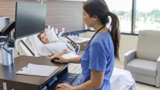 Nurse uses EHR in patient room