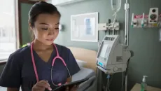 Doctor in a hospital looks up data on a tablet