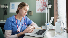 A doctor checking a patient's file on a laptop computer