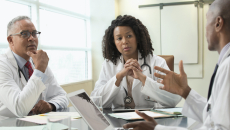 Three clinicians meet at a table