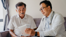 A doctor discussing a patient's health findings using a digital tablet.