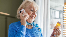 Person on phone holding pill bottle