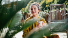 Person holding coffee mug outdoors