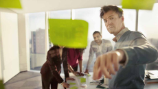 Co-workers reviewing ideas on glass wall_EMEA HITN_Getty-Shannon Fagan
