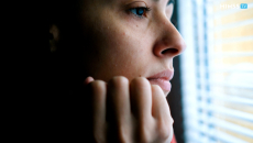 Concerned person looking out of window