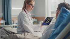 Healthcare worker showing tablet to patient