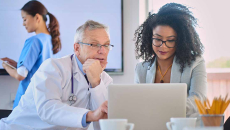 Doctor and businessperson looking at laptop screen