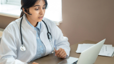 Doctor speaking at laptop