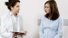 A patient sits with a doctor and seems concerned.