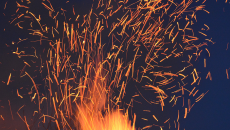 Fire sparks light up a dark sky.