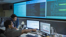 Worker pointing at screen with coworker