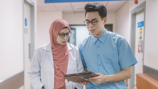 Healthcare workers talking and looking at clipboard
