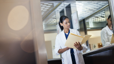 A doctor reviewing a paper patient record
