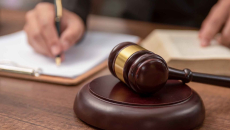 gavel with hand writing in the background