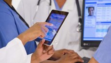 Healthcare workers looking at a medical record on a tablet