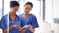 Two nurses check patient montitoring device