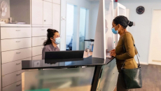 Medical receptionist and patient in masks