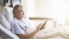 Patient in hospital bed using tablet