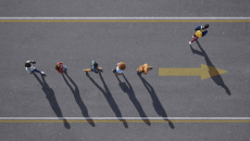 Top down view of people walking in a line on a road