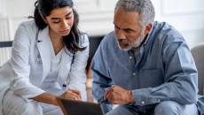 Doctor showing tablet to patient