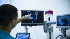 Healthcare worker pointing at x-ray image on monitor
