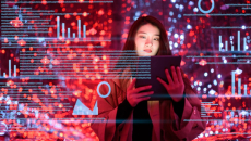 A woman holds up a tablet and data overlays appear all around her.