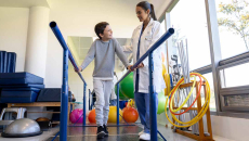 Healthcare worker working with child in physical therapy room