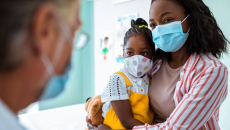 Parent and child in masks seeing doctor