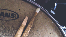Close-up of broken drum stick that lays across an old snare drum