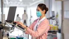 A clinician works in an EHR on a hospital floor.