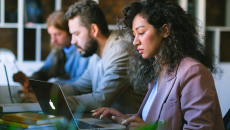 Three people working at laptops