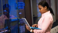 IT checks info on laptop in front of IT room