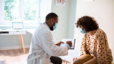 Doctor reviews treatment plan with patient in exam room