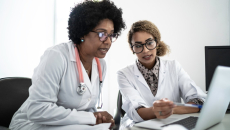 Two health professionals at a laptop