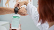 Healthcare worker syncing smartwatch with smartphone app