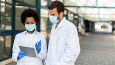 Healthcare professionals in a corridor exmine a tablet