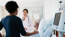 A doctor talking to patient and his family in a hospital room.