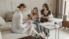 A parent and their kid in a consultation with a doctor