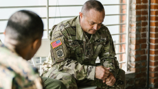 People in army uniforms seated in a discussion