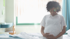 Pregnant person sitting on hospital bed