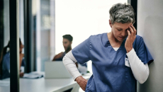Health professional holding hand to face