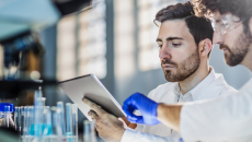 Lab workers looking at a tablet
