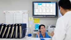 Staff conversing in the nurses' station with the Ascom Digistat Smart Central on the background