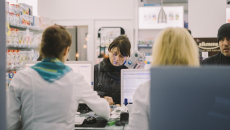 Customers transacting at a pharmacy counter