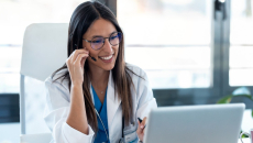 Female doctor with headset smiles on a telehealth visit