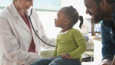 Doctor treating child with parent present