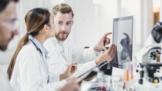 Lab workers looking at a monitor