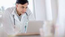 A doctor reviewing a patient's digital record on a laptop