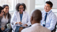 Hospital workers sit around in a meeting