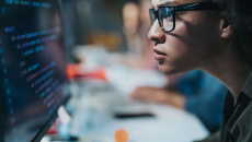 A computer programmer writing codes on a desktop computer